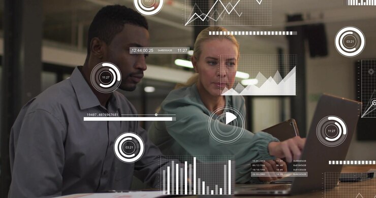 Woman pointing, tapping laptop, guiding peer, causing HUD charts and progress bars for data review