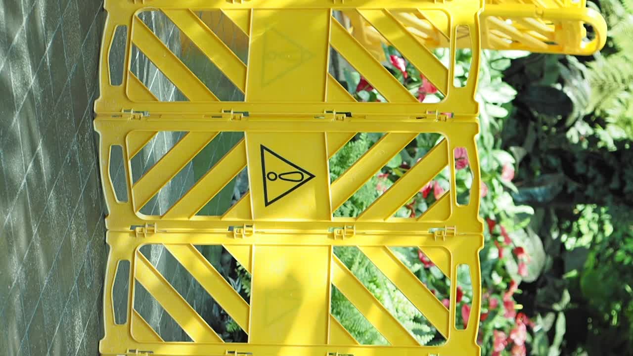 Yellow Plastic Barrier in a Botanical Garden