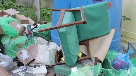 old, broken chair on pile of garbage ready for removal and disposal in romania