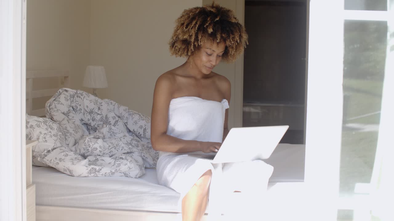Young Woman Using Laptop On Bed