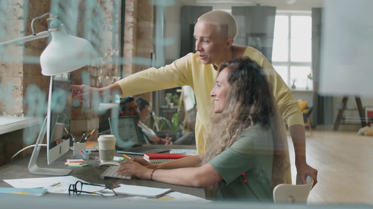 Women Discussing Business Project on Computer in Office