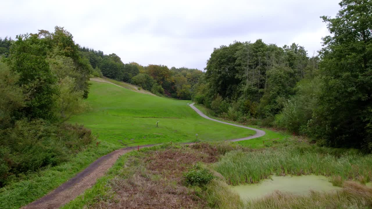 primer plano de bajo ángulo que muestra un campo de golf rodeado de vegetación vibrante y exuberante