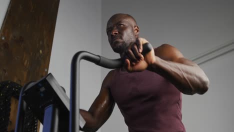 fit african american man exercising on training bike inside gym