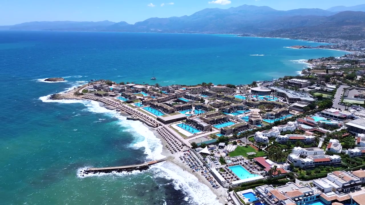 Férias de Luxo no Mediterrâneo: Nana Royal Resort, Praia, Piscinas e Costa Montanhosa em Creta, Grécia, vista aérea orbital