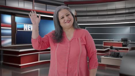 feliz periodista india de alto rango saludando y saludando