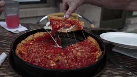 chicago style pizza at lou malnati's pizzeria in evanston, illinois with man serving pizza