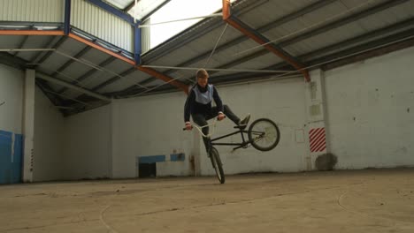 bmx rider in an empty warehouse