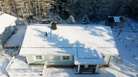 aerial view tilting away from a detached house with snow covered solar panels