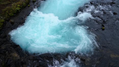 splashing blue colored water of bruara river in iceland - top view