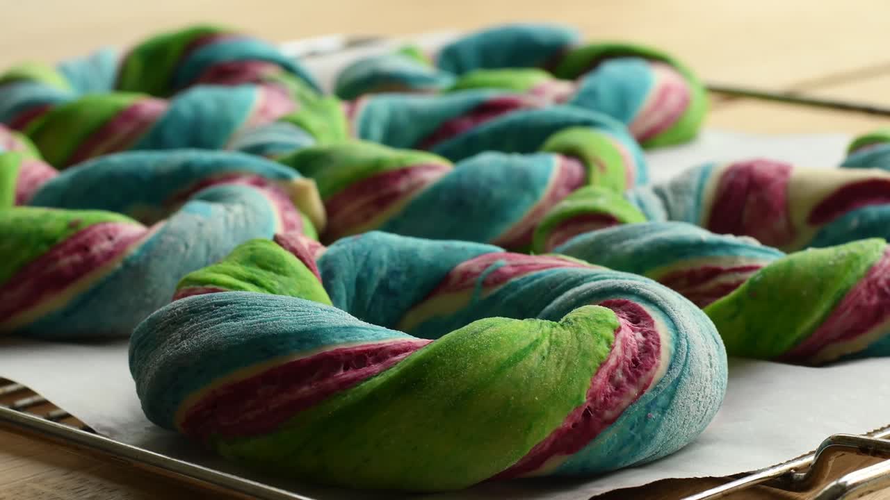 베이킹 트레이에 무지개 색의 베이글 반죽을 추가하는 것