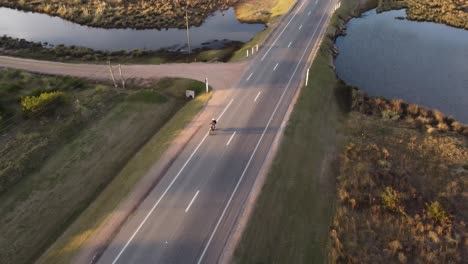 Vista-Aérea-De-La-Conducción-De-Motocicletas-En-La-Carretera-Costera-Cerca-Del-Océano-Atlántico-Al-Atardecer-En-Uruguay