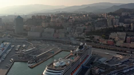 Aerial-pullback-view-of-luxury-cruise-liner-docked-at-Genova-port,-Italy