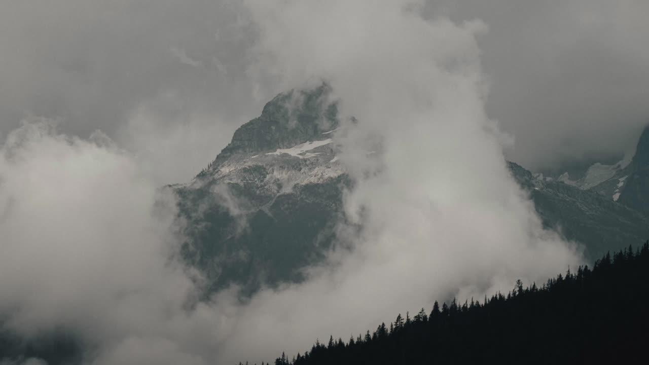 montaña colmillo rojo con nubes en la cordillera tantalus en columbia británica, canadá