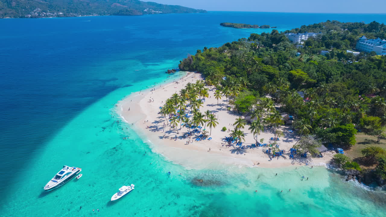 Epico time-lapse aereo che circonda un'isola nei Caraibi con una spiaggia e palme, Cayo Levantado, Repubblica Dominicana