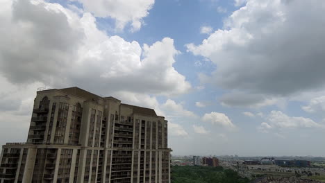 lapso de tiempo de nubes moviéndose sobre un edificio alto y el horizonte de toronto