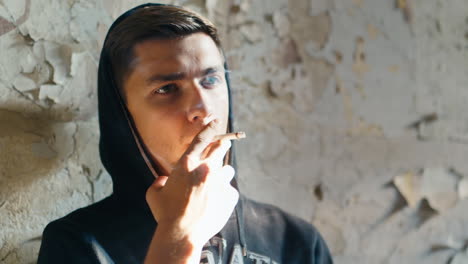 sad young man smoking in an abandoned building 3