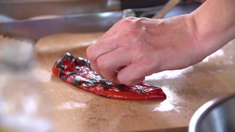 limpieza de pimientos asados con un cuchillo y las manos