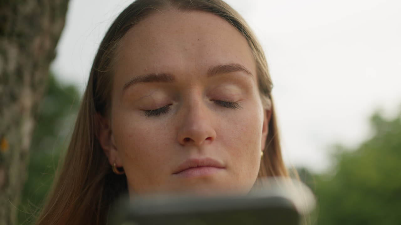 mujer, pensando y sosteniendo el teléfono al aire libre