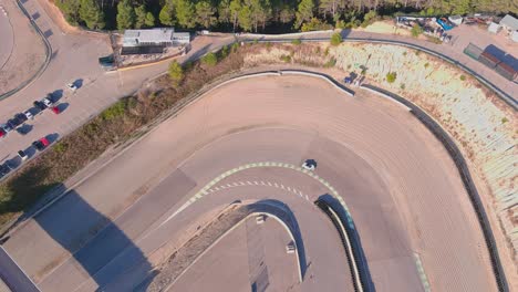 las carreras de coches blancos a través de curvas afiladas en el circuito parcmotor castelloli, barcelona