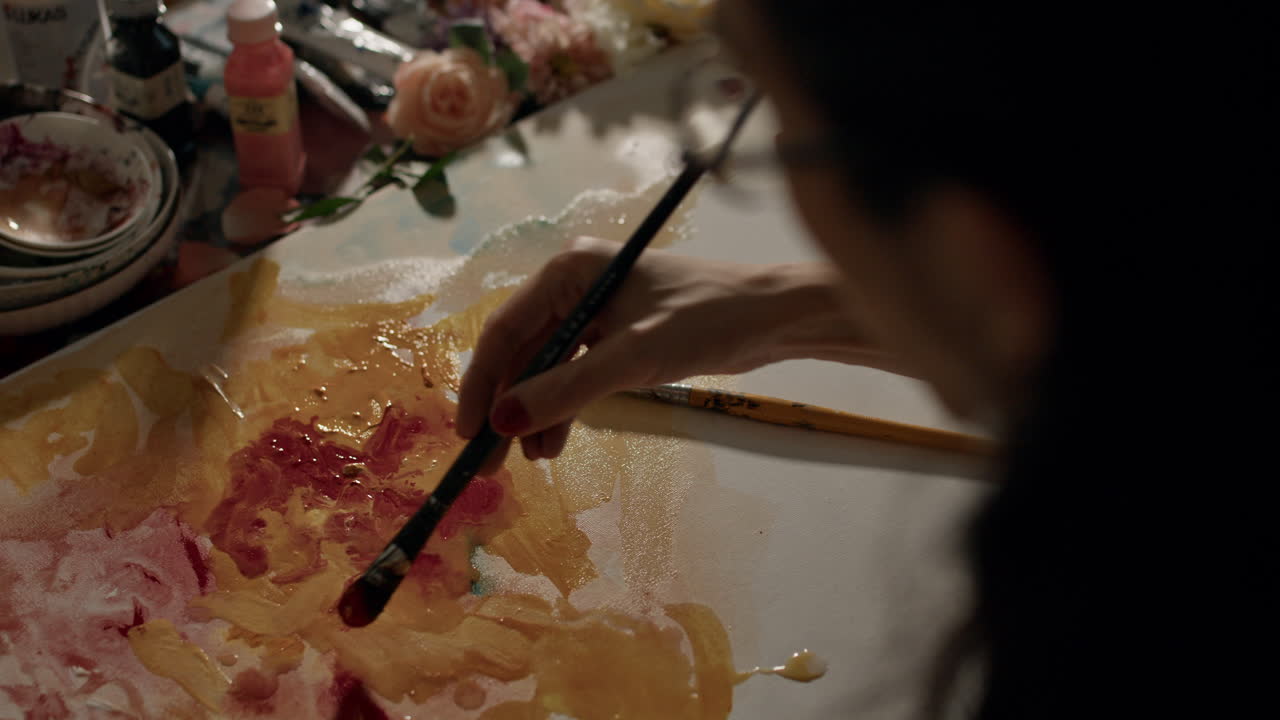 Artist painting with focus, studio creativity, vibrant colors on canvas