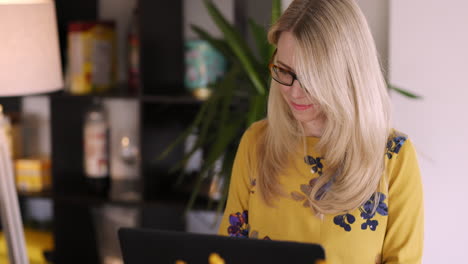 mujer trabajando en una computadora portátil en casa
