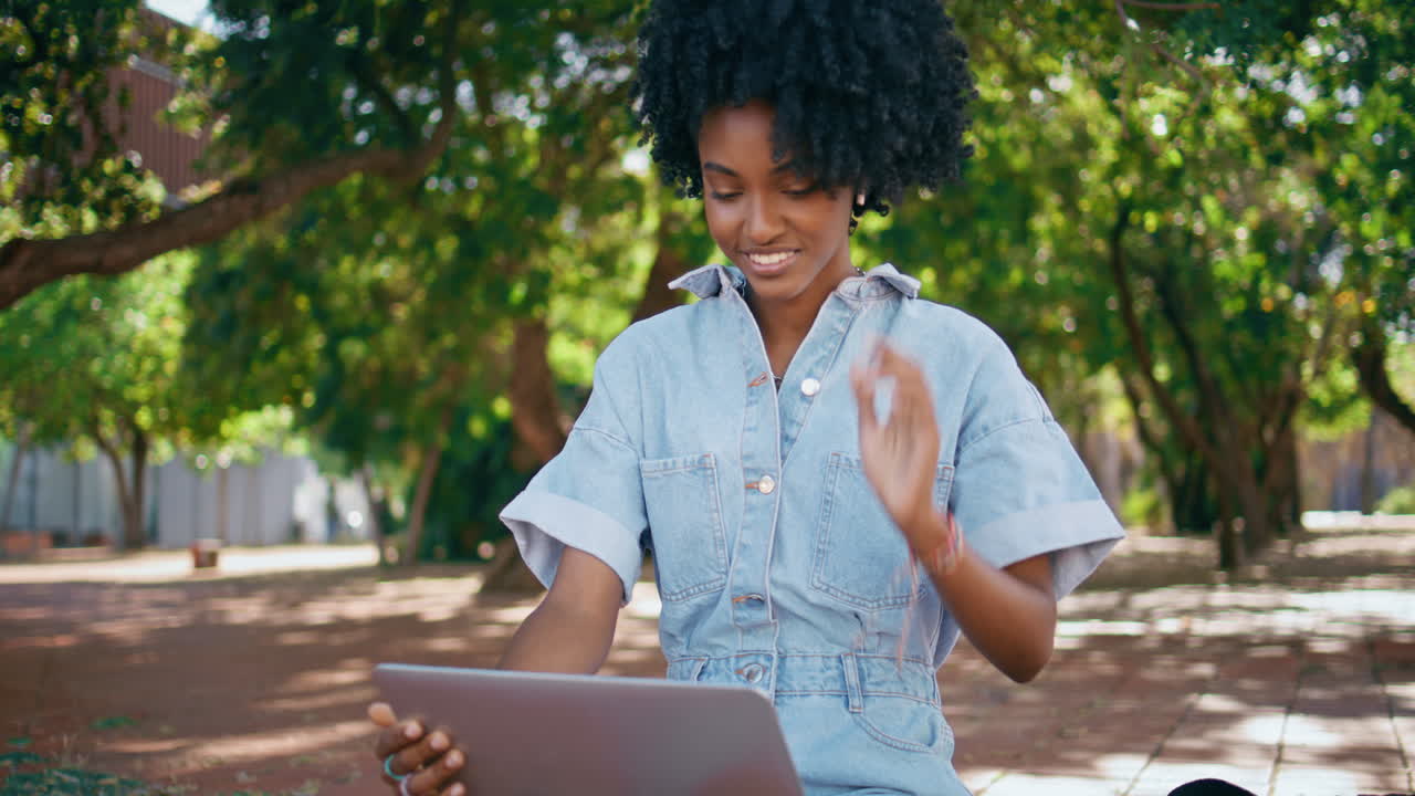 Woman working on laptop in a park