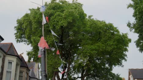 Mittlere-Aufnahme-Einer-Festlichen-Wimpelkette,-Die-An-Einen-Laternenpfahl-Gebunden-Ist