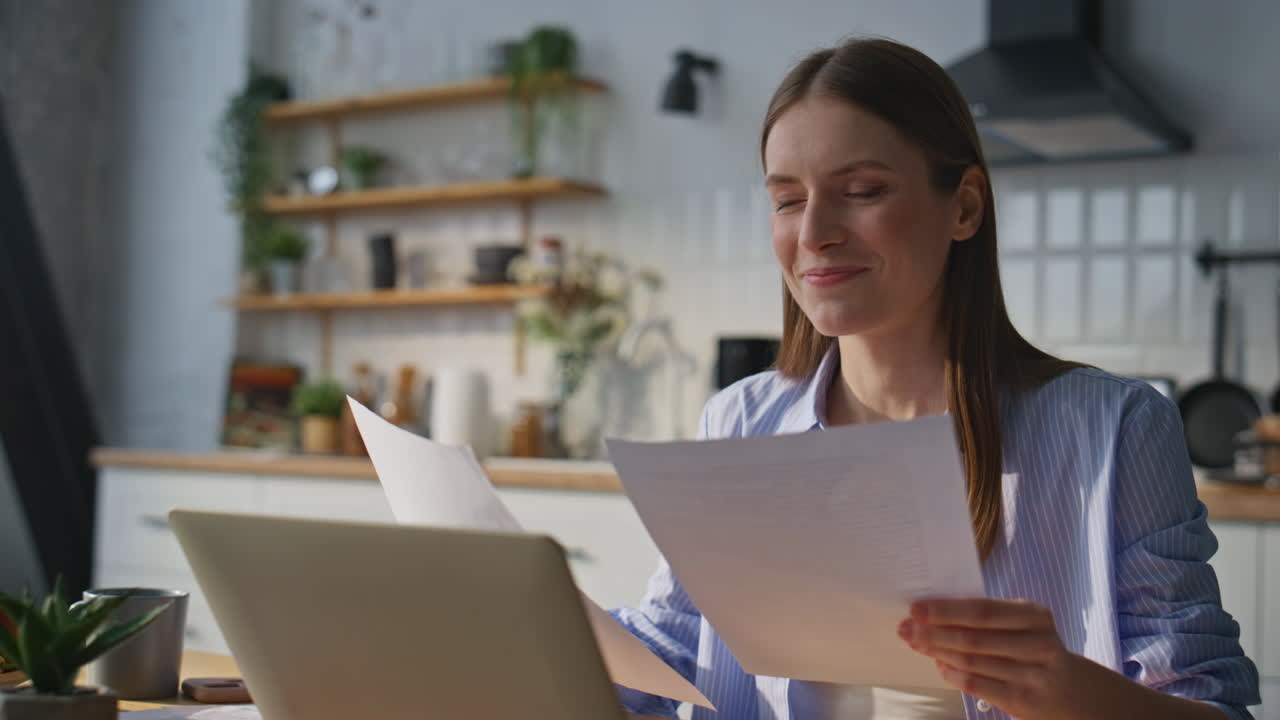 Successful businesswoman looking documents sitting at apartment kitchen closeup