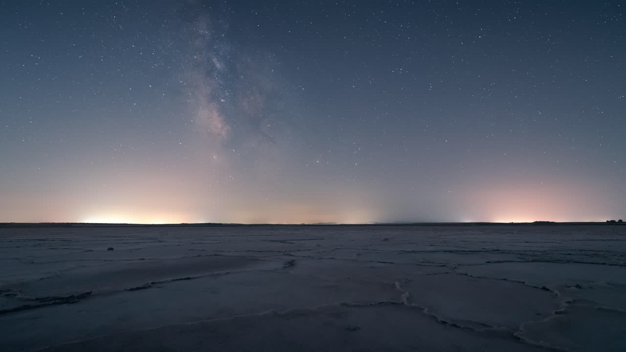 Night timelapse of the Milky Way and moonset above a salt flat in Castilla-La Mancha, Spain, with starry sky and serene desert-like scenery
