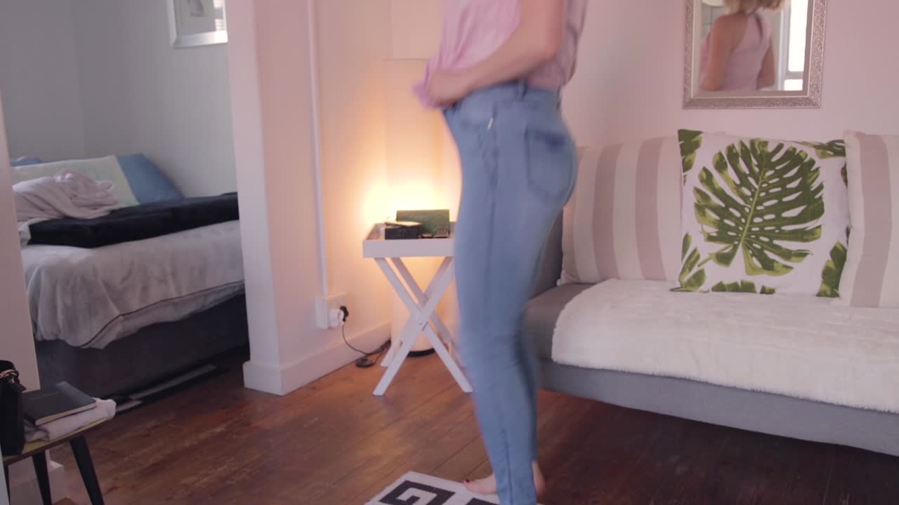Lady running through frame pulling up jeans in a rush