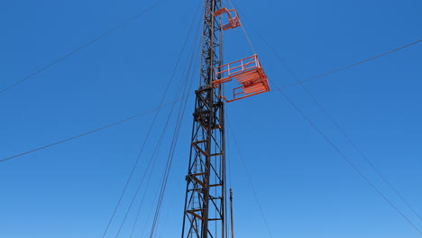 three men standing at the truck with the derrick for oil drilling. low angle view at the tower for boring resources.