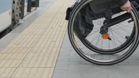 woman in wheelchair at a bus stop goes out from bus / close up