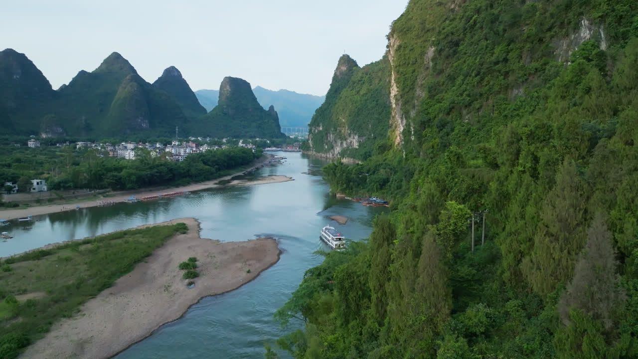 Aerial view revealing a riverboat on Li river, sunset in Xingping, China