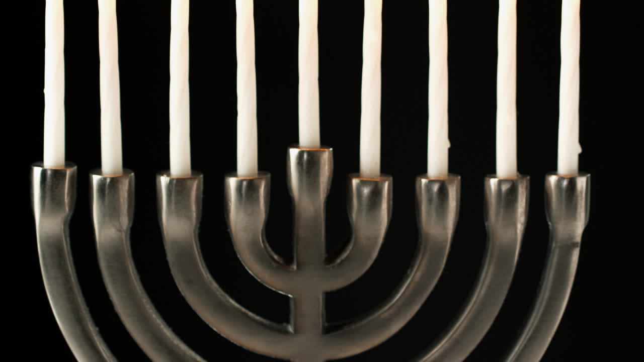 disparo de candelabro de menorá judía con velas encendidas contra un fondo negro