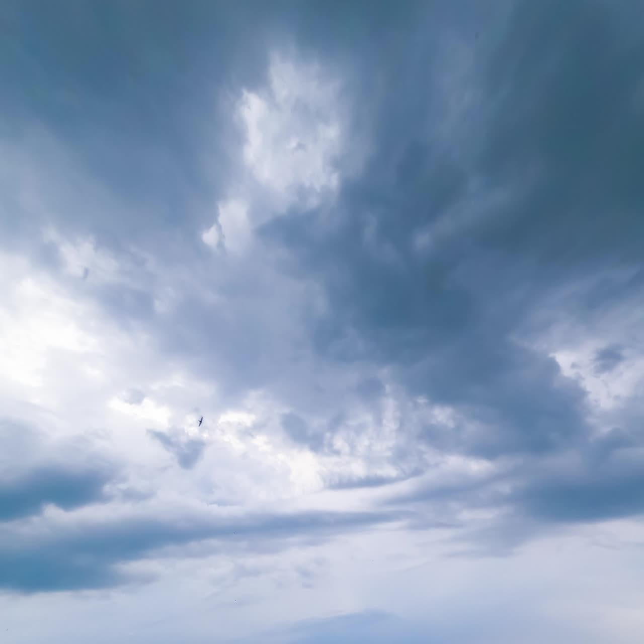 Cloud mass moving around the sky. Dark clouds spreading in the sky. Timelapse low angle view perspective