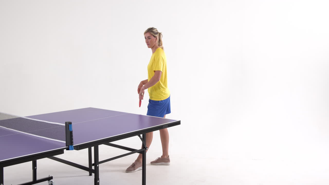 Female table tennis player serving and passing the ball on white background, copy space