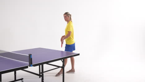 female table tennis player serving and passing the ball on white background, copy space