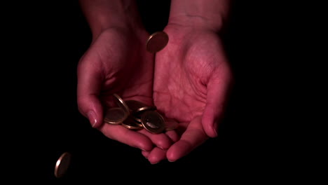 money dropping into hands on black background