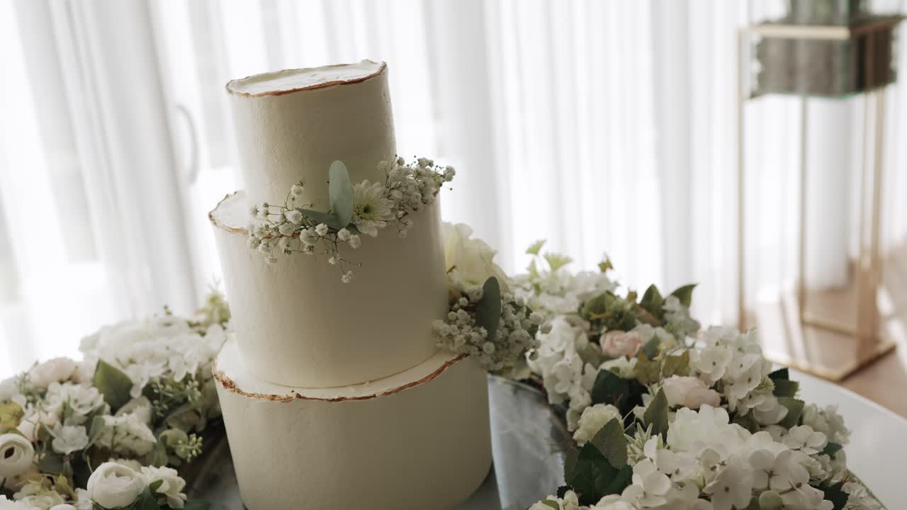 Three tier white wedding cake with baby breath and floral table decoration