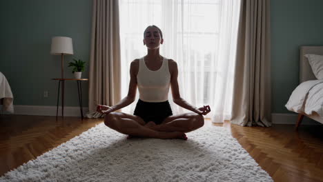 woman meditating in a bedroom