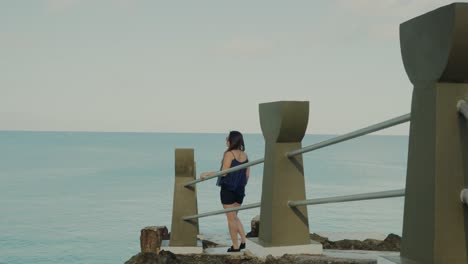 Girl-walking-at-Taga-beach-while-sightseeing,-slow-motion