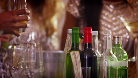 close up of alcohol at party with guests in background