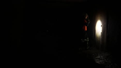 persona explorando un túnel subterráneo oscuro