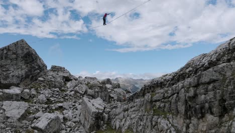 Vuelo-Aéreo-Debajo-De-La-Persona-Que-Se-Balancea-En-Slackline-En-Las-Montañas-Dolomitas---Vista-Espectacular-De-La-Cordillera-Con-Valle-Verde-En-Italia