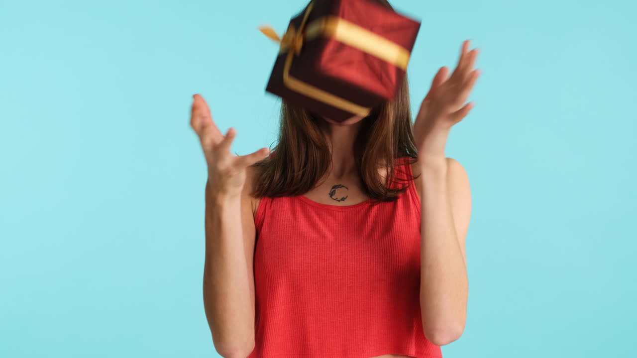 백인 여성이 파란색 배경에 카메라 앞에 포즈를 취하고 있습니다.