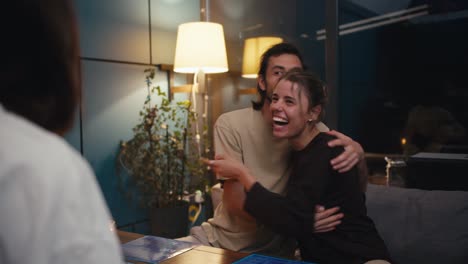 el chico y la chica ganaron el juego de mesa y están muy felices por ello. felices jugando a un juego de mesa en el círculo de amigos en una noche acogedora