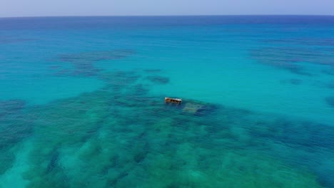 wreck of sunken ship emerging from caribbean waters