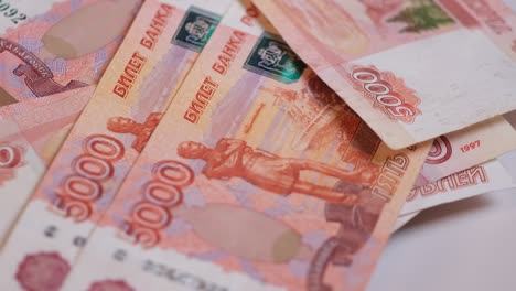 russian banknotes of five-thousandth banknotes fall from above onto the money rotating on the platform.