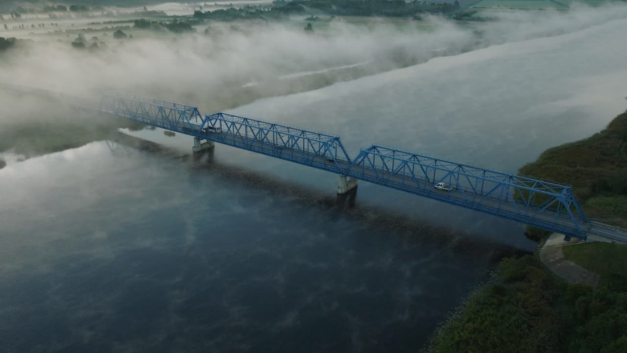 ⁇ 은 여름 아침에 젤루페 강을 가로지르는 철강 다리의 공중 뷰, 강 위로 떠오르는 안개, 자동차 운전, 넓은  ⁇ 도 드론  ⁇