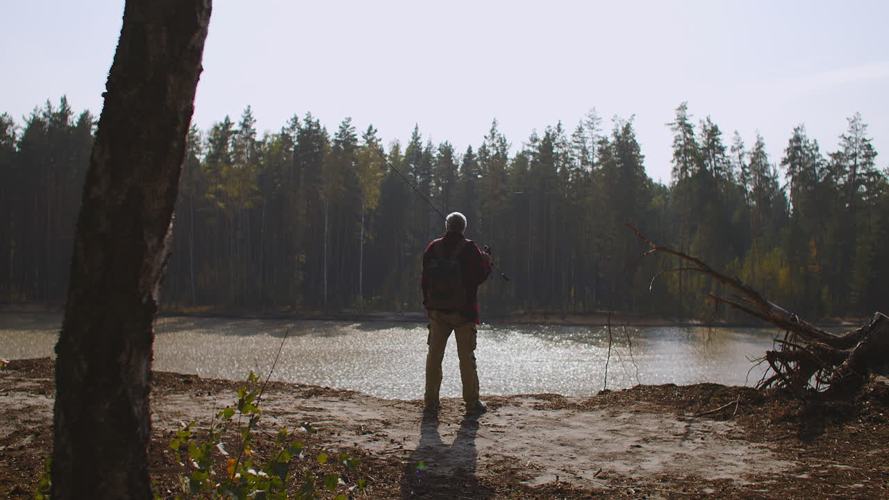 pescador es inspirador por la naturaleza viendo en el río o el lago en la temporada de otoño vista trasera de un hombre de mediana edad en el acantilado